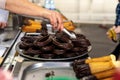 Fried dough, traditional Spanish breakfast churros bathed in chocolate, delivered by a saleswoman to a client Royalty Free Stock Photo