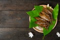 Fried dried fish on mango leaf in wooden dish on wooden table Royalty Free Stock Photo