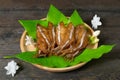 Fried dried fish on mango leaf in wooden dish on wooden table Royalty Free Stock Photo
