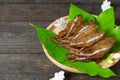 Fried dried fish on mango leaf in wooden dish on wooden table Royalty Free Stock Photo