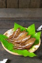 Fried dried fish on mango leaf in wooden dish on wooden table Royalty Free Stock Photo
