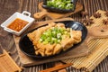 Fried dried follower in a dish chilli sauce isolated on wooden board side view on table taiwan food