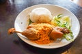 Fried duck served with fresh vegetables and chili sauce on a white plate