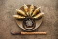 Fried dumplings Gyoza on a plate, soy sauce, and chopsticks on a stone background Royalty Free Stock Photo