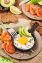 Fried egg, avocado and smoked salmon in frying pan Royalty Free Stock Photo