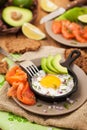 Fried egg, avocado and smoked salmon in frying pan Royalty Free Stock Photo