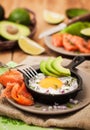 Fried egg, avocado and smoked salmon in frying pan Royalty Free Stock Photo