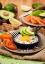 Fried egg, avocado and smoked salmon in frying pan Royalty Free Stock Photo