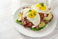 Fried egg, bacon and avocado on a dark whole meal bread with lettuce and tomato, delicious breakfast sandwich, light background, Royalty Free Stock Photo