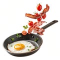 Fried egg bacon and cherry tomatoes flying into iron skillet isolated on white background Royalty Free Stock Photo