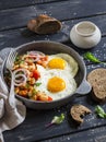 Fried egg, beans in tomato sauce with onions and carrots, fresh cucumbers and tomatoes, homemade rye bread - delicious breakfast Royalty Free Stock Photo