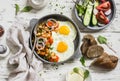 Fried egg, beans in tomato sauce with onions and carrots, fresh cucumbers and tomatoes, homemade rye bread - delicious breakfast