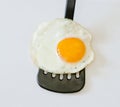 Fried egg on a black spatula