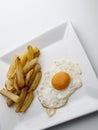 A fried egg with chips on a square plate Royalty Free Stock Photo