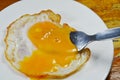 Fried egg with creamy yolk while fork stab