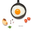 Fried egg in a frying pan isolated on white background with tomato, toast and spices. Creative layout. Breakfast concept. Top view Royalty Free Stock Photo