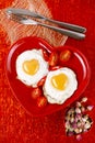 Fried egg with heart shape yolks and rose tea Royalty Free Stock Photo
