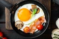 Fried Egg with ingredients in cast iron frying pan  on old dark wooden table background  top view flat lay Royalty Free Stock Photo