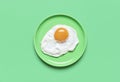 Fried egg on minimalist on a green background, view from above Royalty Free Stock Photo