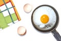 Fried egg on the pan, dish towel and egg shells on the white background. Royalty Free Stock Photo