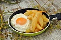 Fried egg with potatoes, served in a pan