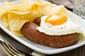 Fried egg with sausage and chips on plate Royalty Free Stock Photo