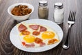 Fried egg with sausage in dish, salt, pepper, eggplants Royalty Free Stock Photo