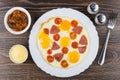 Fried egg with sausage and tomatoes in dish, spices, eggplants Royalty Free Stock Photo