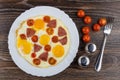 Fried egg with sausage and tomatoes in dish, salt, pepper Royalty Free Stock Photo
