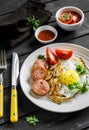 Fried egg, sausage, tomatoes - tasty Breakfast or snack, on the bright plate Royalty Free Stock Photo