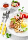 Fried egg, sausage, tomatoes - tasty Breakfast or snack, on the bright plate Royalty Free Stock Photo