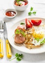 Fried egg, sausage, tomatoes - tasty Breakfast or snack, on the bright plate Royalty Free Stock Photo