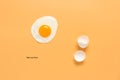 Fried egg and shells on a pastel yellow background. Creative layout. Minimalistic still life. Breakfast concept. Top view, flat Royalty Free Stock Photo