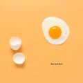 Fried egg and shells on a pastel yellow background. Creative layout. Minimalistic still life. Breakfast concept. Top view, flat Royalty Free Stock Photo