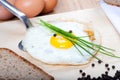 Fried egg on silver spatula with parsley, bread and spice