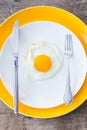 Fried egg on a white, yellow plate. Restaurant. Breakfast