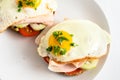 Fried egg on wholemeal bread roll with tomato, cucumber and cooked ham, healthy hearty breakfast on a white table, copy space, Royalty Free Stock Photo