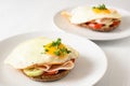 Fried egg on wholemeal bread roll with tomato, cucumber and cooked ham, healthy hearty breakfast on a white table, copy space Royalty Free Stock Photo