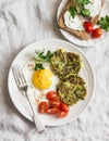 Fried egg, zucchini fritters and cream cheese sandwich - delicious breakfast, brunch or snack. On a light background