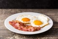 Fried eggs and bacon for breakfast on wood Royalty Free Stock Photo
