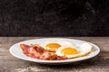 Fried eggs and bacon for breakfast on wood Royalty Free Stock Photo