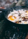 Fried eggs with bacon and dor blue. in a pan in the forest. Food at the camp. Fried egg with bacon on fire. Picnic Royalty Free Stock Photo