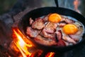 Fried eggs with bacon in a pan in the forest. Food at the camp. Fried egg with bacon on fire. Picnic Royalty Free Stock Photo