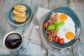 Fried eggs,  bacon, tomato, toast and a cup of coffee Royalty Free Stock Photo