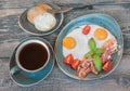 Fried eggs, bacon, tomato, toast and a cup of coffee Royalty Free Stock Photo