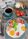 Fried eggs, bacon, tomato, toast and a cup of coffee Royalty Free Stock Photo