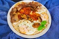 Fried eggs with bacon, tomatoes and mushrooms on dark background. Top view