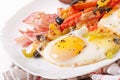 Fried eggs with bacon, tomatoes, olives and slices of cheese Royalty Free Stock Photo