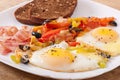 Fried eggs with bacon, tomatoes, olives and slices of cheese Royalty Free Stock Photo