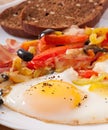 Fried eggs with bacon, tomatoes, olives and slices of cheese Royalty Free Stock Photo